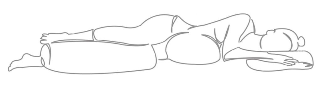 pregnant woman lying with leg over a bolster